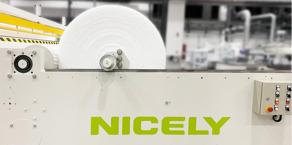 NICELY Machinery nonwoven slitter rewinder processing a large parent roll of hot air bonded nonwoven fabric.